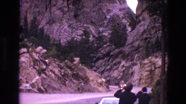 1974: visitors taking pictures of a very tall mountain. SOUTH DAKOTA