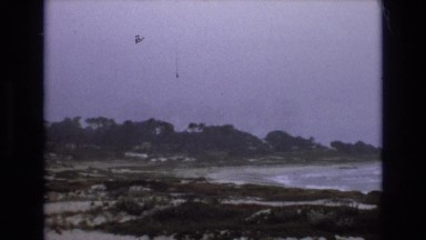 1965: wintry beach, with lacy snow on the sand near where foamy waters