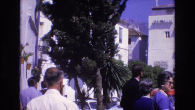 1969: people walking by a beautiful water fountain on a busy european street