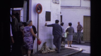 1969: footage of a busy street corner in a crowded town square. SPAIN