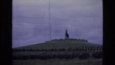 1969: statue building atop a hill in the distance while driving SPAIN