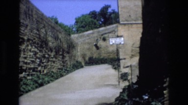 1969: people walking up to an ancient building on a tourist guide. SPAIN
