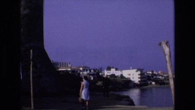 1969: wharf and boat dock on a harbor in the 1960s with woman crossing