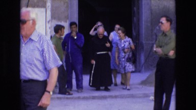 1969: Old Caucasian Lady Walking Out of Church with Clergy in Spain