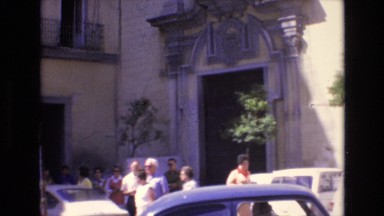 1969: lonely hotel building with people down below, walking around. SPAIN