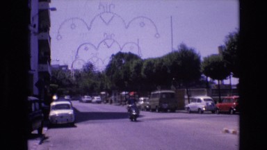 1969: vehicles moving on the road and some are parked