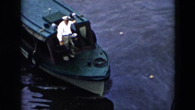 1956: the captain of a tugboat stands on the boat as it comes to a stop CUBA
