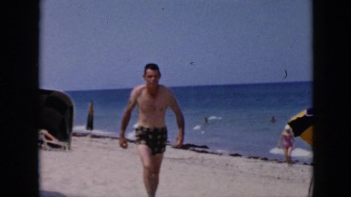 1956: beach-goers walk on sandy beach and a woman removes her swimming cap CUBA