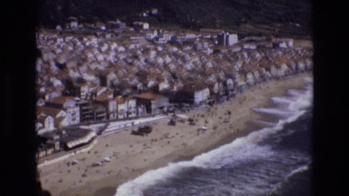1972: Aerial View of a Crowded Beach and Ocean Waves Portugal