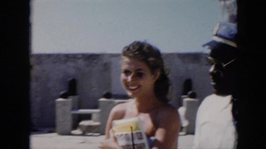 1956: a black man in uniform leads a young white woman to an introduction CUBA