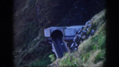 1961: a car exiting from a tunnel opening on the side of a mountain HAWAII