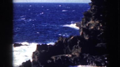 1961: waves washes up on the rocks. HAWAII