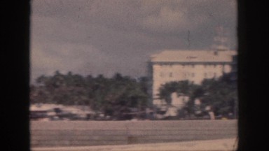 1961: battleship on ocean to buildings by fields HAWAII