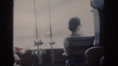 1961: watching from the back of the boat as two fishermen look out waiting