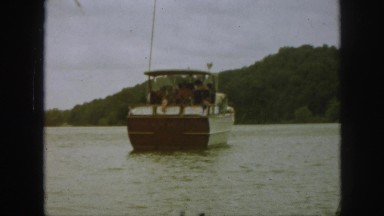 1961: idyllic motorboat with american flag on calm summer lake with rays