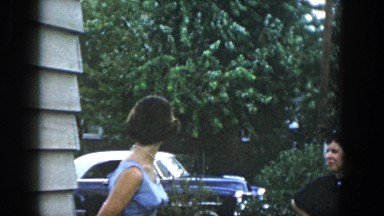 1958: Two Women Standing Outside Having a Conversation and a Man Smoking Dayton