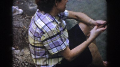 1958: a barefoot person poking a large stick in the water