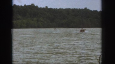 1961: People Water Skiing Behind Boat on Calm Michigan Lake