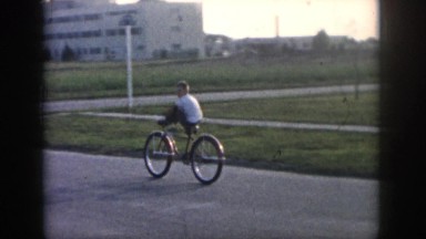 1958: boy riding bike down street past hospital NEW ORLEANS LOUISIANA