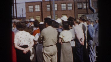 1958: gathered crowd eagerly looking for someone/something in a open place