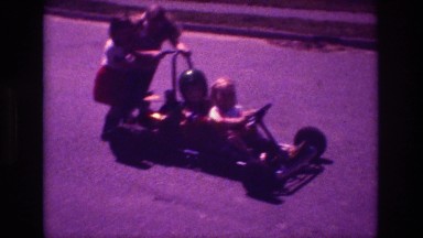 1981: Kid Pretending to Drive Nascar on Street with Relatives in San Diego