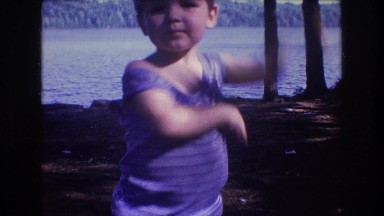 1975: a small child performs a simple dance routine with the ocean