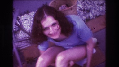 1975: a woman wearing bathing suit is laughing a lot sitting