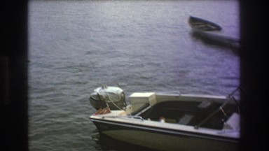 1975: some people standing on the shore of a lake with many boats BOSTON