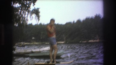 1975: man standing next to the lake, trying to decide to jump in or not. BOSTON