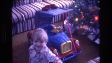 1975: child happy got christmas present toy blue car sitting inside