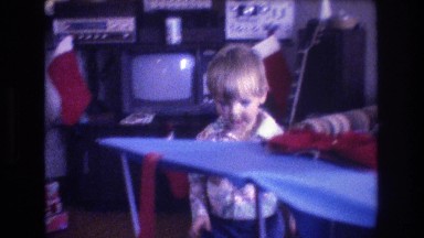 1975: a cute body is taking boxes of presents and throws on the table BAXTER