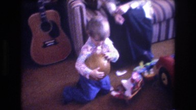 1975: cute child indoor playing and throwing a ball BAXTER MAINE