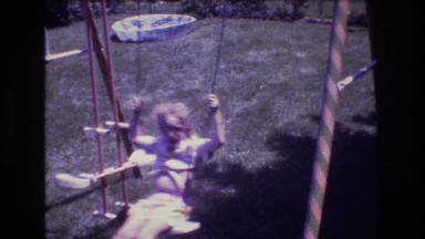 1976: two children swinging on swingset with glider seat swing