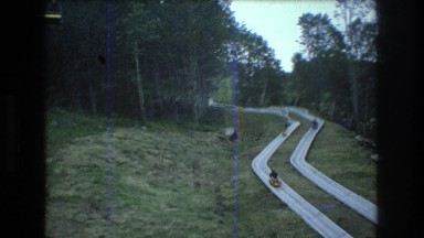 1976: small cars are moving through a road constructed amid the forest MT