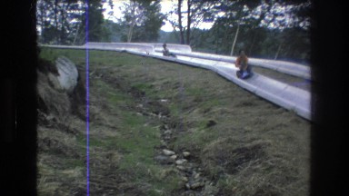 1976: pair of adventurous youths grind to a stop during a summer luge run