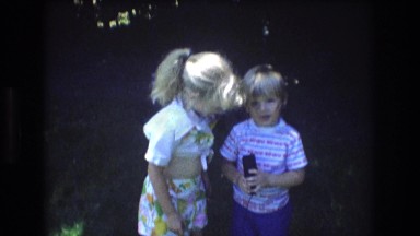 1976: cute girl boy standing laughing smiling trees around