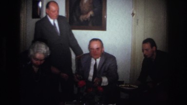 1967: men sitting wearing coat tie talking portrait on walls