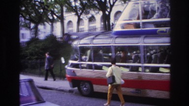 1967: woman walking by bus in city with car passing by PARIS FRANCE