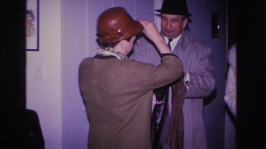 1966: indoor party scene man helping wife put on jacket love together HOBOKEN