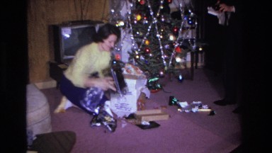1966: woman opening her gift on christmas morning. HOBOKEN NEW JERSEY