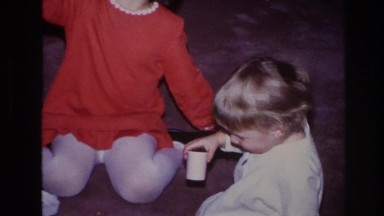 1966: two young girls with short hair sitting and playing with each other