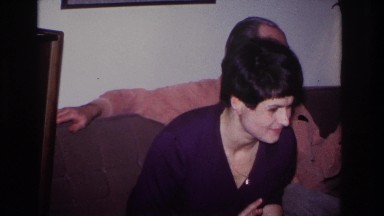 1966: a woman, who appears to be uncomfortable, sitting next to a man on a couch