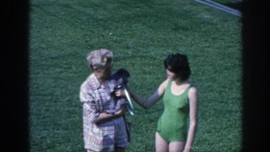 1963: an old mom with a puppy stands on the meadow beside a young lady and walks