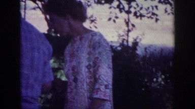 1962: people standing garden man watching white puppy playing