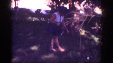 1962: family garden lady plucking flowers walking holding puppy wearing hat