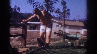 1962: shirtless man plants tree by fence BLAINSPORT PENNSYLVANIA