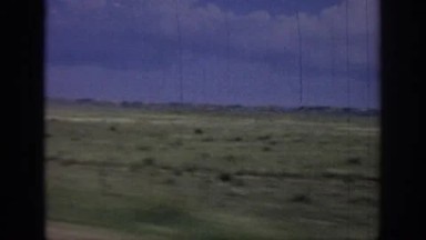 1967: Desert Filled with Sage Brush Borders a Highway