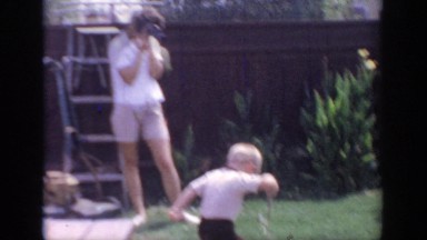 1967: two children are playing in the back yard and are being filmed