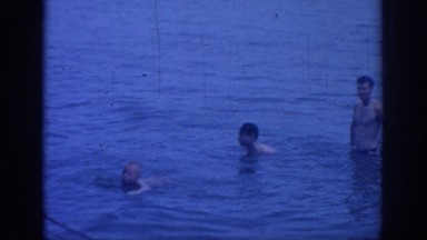 1967: men and children wading and swimming in a lake on a summer day OKLAHOMA
