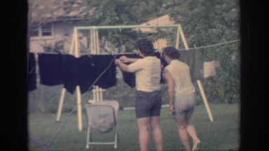 1967: two women outside in the yard hanging clothes on the clothesline OKLAHOMA